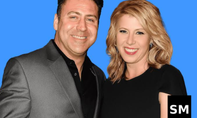 Two people posing against blue background.