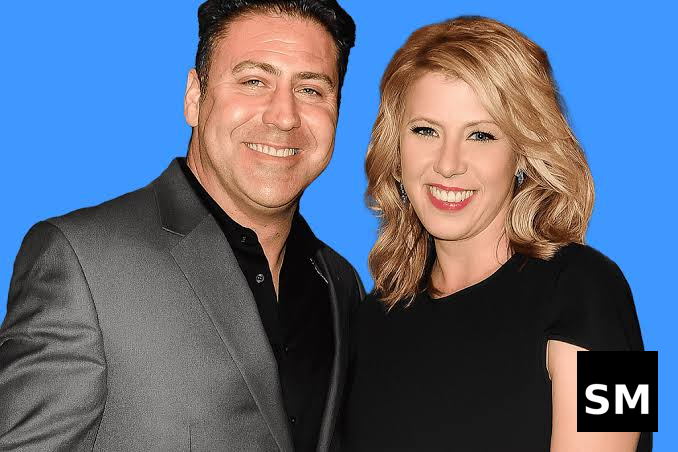 Two people posing against blue background.