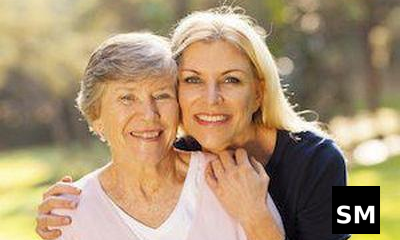 Two women smiling outdoors together.