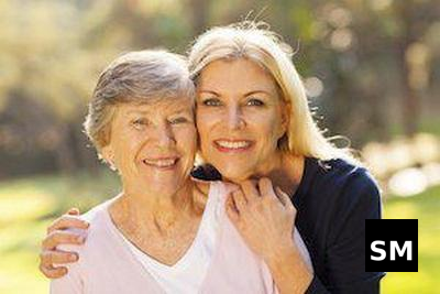 Two women smiling outdoors together.